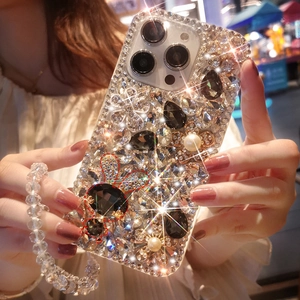 Close-up of luxury iPhone case with crystals, pearls, rabbit charm and beaded wrist strap