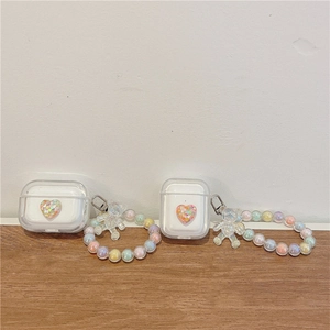 Detail view of AirPods cases with colorful sequins heart design and beaded bear wristlet