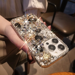 Detailed luxury iPhone case featuring silver rhinestones, pearls, and black crystal flowers