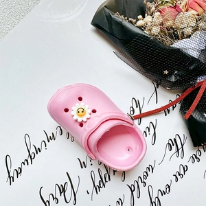 Detailed view of pink EVA kids clogs with cute white sunflower smile charms decoration