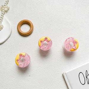 Detailed macro view of 3D resin donut phone socket stands on a textured background