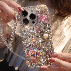 Detailed macro of luxury iPhone case with rhinestones, pearls, and beaded wrist strap