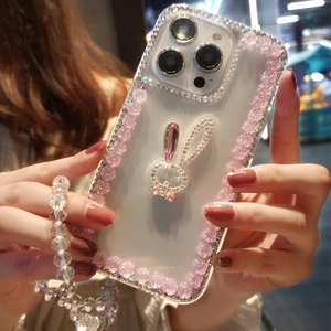 Detail of luxury rhinestone rabbit and pink resin flowers on a clear iPhone case