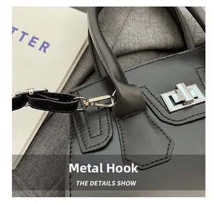 Detail of silver hardware hook and adjustable leather strap on a black chic handbag