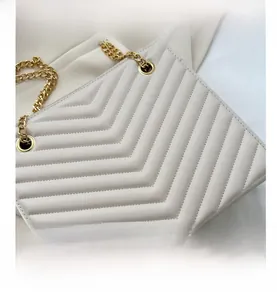 Detail of cream quilted PU leather bag with elegant gold chain strap and stitching