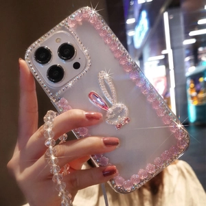 Detail of luxury rhinestone rabbit and pink flower charms on transparent iPhone case