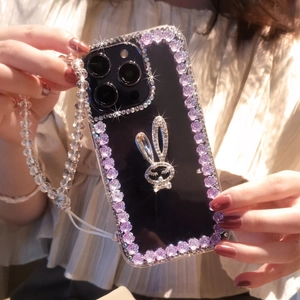 Detailed close-up of a luxury iPhone case with rhinestone rabbit and purple flower charms