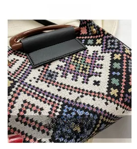 Detail of woven bucket bag with retro plaid pattern and round brown wooden handle