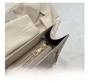 Detail of premium beige quilted tote bag showing smooth gold metal zipper and PU leather texture