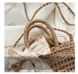 Detail einer geflochtenen Strohhandtasche mit Spitzen-Schleife und sicherem Kordelzug