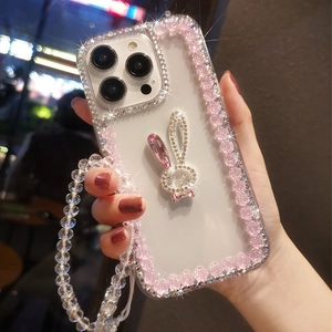 Detail of luxury clear iPhone case with resin rose edges and rhinestone rabbit with bead strap