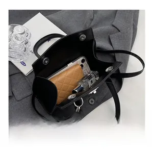 Detailed interior view of a black PU leather bag showing spacious storage for daily essentials