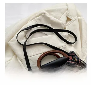Detail view of ethnic jacquard bucket bag with wooden round handle and leather strap