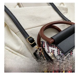Detail view of the colorful woven fabric with gold metal buckle and leather strap