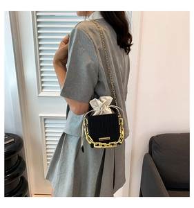 Detail of black chain bucket bag with gold hardware and contrast drawstring inner pouch