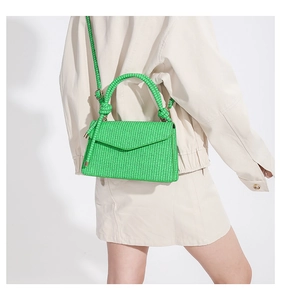 Hellgrüne geflochtene Umhängetasche kombiniert mit einem beigen minimalistischen Outfit