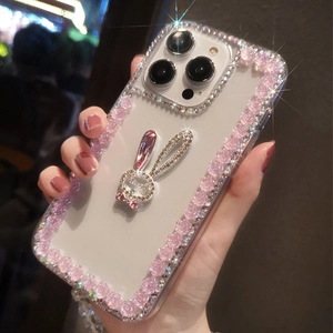 Detail of luxury rhinestone rabbit and pink flower embellishments on clear iPhone case