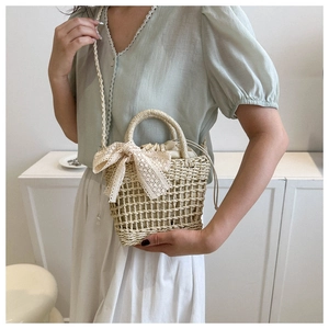 Detail of handmade straw crossbody bag with lace bow and drawstring inner lining