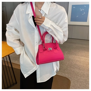 Rose red handbag with silver twist lock worn with white shirt in a minimalist room