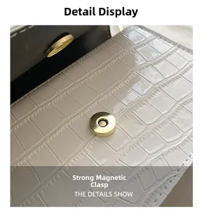 Détail du fermoir magnétique doré sur un sac à main blanc avec motif crocodile