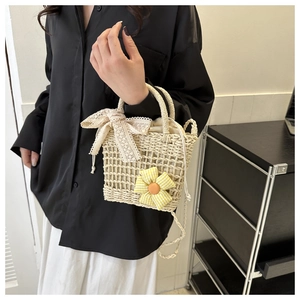 Detailansicht der Strohtasche mit Spitzenschleife und gelber Sonnenblume