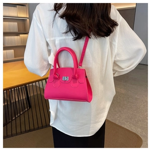 Back view of a rose pink mini trapezoid handbag with a metal twist lock and shoulder strap
