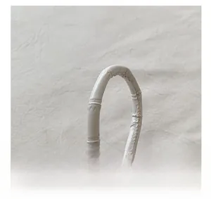 Détail de la poignée de sac blanche avec texture bambou et surpiqûres soignées