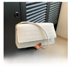 Détails du sac carré blanc motif crocodile avec finitions dorées et rabat rectangulaire