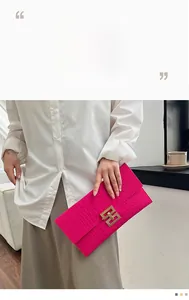 Handheld magenta envelope clutch with crocodile embossed texture and golden clasp