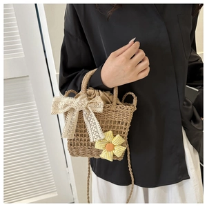 Detail of straw woven bag with lace bow, floral decor and drawstring lining