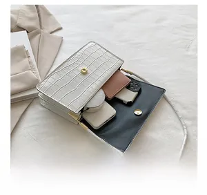 Vue détaillée de la capacité intérieure du sac blanc à motif pierre avec mobile et portefeuille