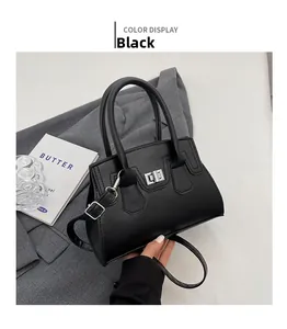 Close-up of black Boston style handbag with silver swivel lock and thin adjustable strap