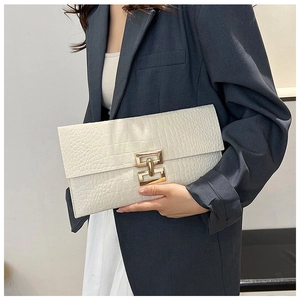Close-up of white crocodile texture envelope clutch bag with gold geometric buckle