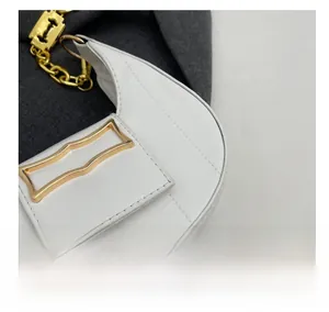 Détail d'un sac demi-lune blanc avec cuir texturé et bandoulière en chaîne dorée chic