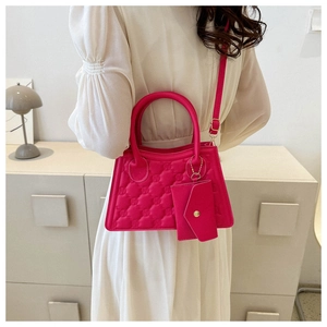 Detail of rose pink quilted crossbody bag with small envelope pouch and fine texture