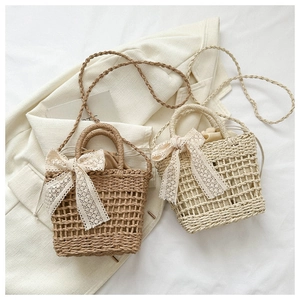 Close-up of hand-woven bucket bags featuring lace bows and adjustable shoulder straps