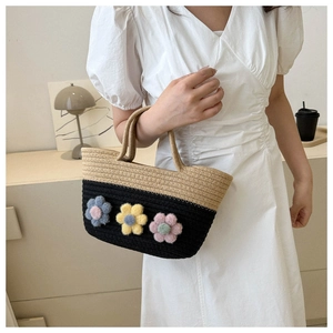 Détail d'un sac seau bicolore tissé avec fleurs 3D et doubles poignées résistantes