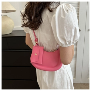Detail of pink crescent underarm bag with matching mini pouch charm and smooth texture