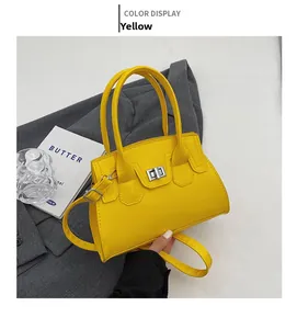 Detail of yellow leather handbag with silver twist lock and slim shoulder strap