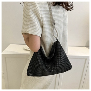 Detail of black rhinestone hobo bag with a stylish silver knotted chain strap