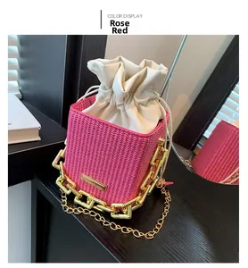Detail of rose red woven bucket bag with golden chunky chain and drawstring closure