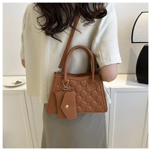 Brown quilted crossbody bag with matching envelope charm and circular embossed pattern