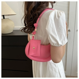 Detail of bright pink crescent shoulder bag with knotted strap and mini pouch
