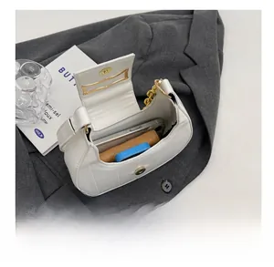 Capacité interne du sac hobo blanc avec téléphone et portefeuille sur un blazer