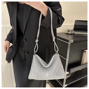 Silver rhinestone hobo bag with knotted strap detail shown in a stylish office setting