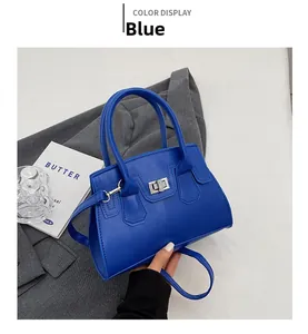 Detailed view of the bright blue PU leather handbag featuring silver metal twist lock
