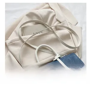 Detail van de kleurblok crossbodytas met denim stiksel en een brede comfortabele schouderriem