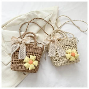 Detail of handmade woven straw bags with lace bows and yellow sunflower accents