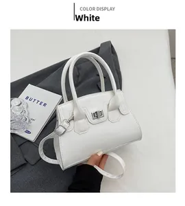 Detail of white PU leather handbag featuring silver twist lock and adjustable shoulder strap