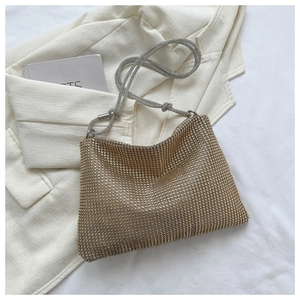 Detail of champagne gold rhinestone evening bag with elegant silver chain knot handle